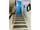 A staircase with painted white risers and contrasting wood treads, featuring modern decor at 2285 Seven Oaks Dr, St Cloud, FL 34772