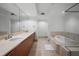Luxury bathroom with double sinks, soaking tub, and a glass-enclosed shower at 231 Riverside Dr # 708, Daytona Beach, FL 32117