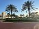 Beautiful entrance with lush landscaping and palm trees against a clear blue sky at 231 Riverside Dr # 708, Daytona Beach, FL 32117