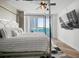 Inviting primary bedroom with canopy bed, fan, and water view from sliding glass doors at 231 Riverside Dr # 708, Daytona Beach, FL 32117