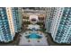 Aerial view of a community pool surrounded by palm trees and lounge chairs at 231 Riverside Dr # 708, Daytona Beach, FL 32117