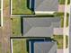 An aerial view showcasing houses with well-maintained roofs and green lawns, surrounded by white fences and a paved sidewalk at 2311 Bear Peak Road, Minneola, FL 34715