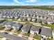 Expansive aerial shot of a Primary-planned community displaying numerous well-maintained homes, showcasing organized neighborhood layout at 2311 Bear Peak Road, Minneola, FL 34715