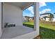 A quaint back porch offers relaxing outdoor space with views of the well-maintained lawn and nearby houses under a sunny sky at 2311 Bear Peak Road, Minneola, FL 34715