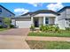 Single Gathering home featuring a brick driveway, two-car garage, and a cozy front porch at 2311 Bear Peak Road, Minneola, FL 34715