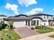 Charming single Gathering home featuring a brick driveway, two-car garage, and a cozy front porch at 2311 Bear Peak Road, Minneola, FL 34715