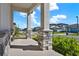 Inviting front porch with stone-clad columns and a view of the neighborhood street at 2311 Bear Peak Road, Minneola, FL 34715