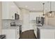 Contemporary kitchen showcasing white cabinetry, stainless steel appliances, and dark wood flooring at 2311 Bear Peak Road, Minneola, FL 34715