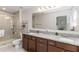A bathroom featuring double sinks, a walk-in shower, and granite counters at 233 Primrose Dr, Davenport, FL 33837