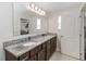 A bathroom featuring double sinks with dark wood cabinetry and granite counters at 233 Primrose Dr, Davenport, FL 33837