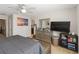 A comfortable bedroom with neutral carpet and decor with TV, dresser, and accents at 233 Primrose Dr, Davenport, FL 33837