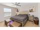Bright bedroom features neutral walls, ceiling fan, and stylish silver bed frame with an upholstered headboard at 233 Primrose Dr, Davenport, FL 33837