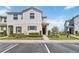Charming two-story townhome featuring lush landscaping, with a inviting entrance and convenient parking spaces at 233 Primrose Dr, Davenport, FL 33837