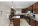 Inviting kitchen with dark wood cabinets, granite countertops, island seating, and modern appliances at 233 Primrose Dr, Davenport, FL 33837