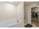 Bathroom featuring tub, glass shower, and walk-in closet at 2412 Twin Lake View Rd, Winter Haven, FL 33881