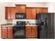Efficient kitchen with dark appliances, granite countertops, gas range, and wooden cabinets at 2412 Twin Lake View Rd, Winter Haven, FL 33881