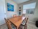 Dining room with a wooden table, four chairs, a window, and coastal decor at 2480 Alamanda Ave, Deltona, FL 32738