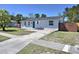 View of the home's exterior featuring a driveway and a well-manicured lawn, complemented by lush trees at 2480 Alamanda Ave, Deltona, FL 32738