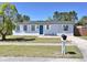 Charming single-story home with well-maintained lawn, light blue exterior, and a vibrant blue front door at 2480 Alamanda Ave, Deltona, FL 32738