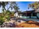 Landscaped backyard featuring a brick patio and view of the property with mature trees and garden at 2713 Lime Tree Dr, Edgewater, FL 32141