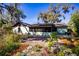 Charming backyard with brick patio, seating area, and lush landscaping under beautiful trees at 2713 Lime Tree Dr, Edgewater, FL 32141