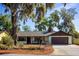 Beautiful home with a manicured lawn, mature trees, and an attached garage at 2713 Lime Tree Dr, Edgewater, FL 32141