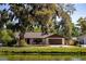 Quaint home nestled among mature trees offering a peaceful curb appeal and a welcoming front porch at 2713 Lime Tree Dr, Edgewater, FL 32141