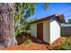 Exterior shot of an outbuilding with a wood door, ideal for storage or workshop at 2713 Lime Tree Dr, Edgewater, FL 32141