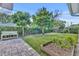 Landscaped backyard featuring a bench, brick pavers, garden, trimmed bushes and trees at 2732 Lion Heart Rd, Winter Park, FL 32792
