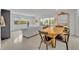 Well-lit dining area with a modern table set, comfortable couch, and view of the outdoor foliage at 2732 Lion Heart Rd, Winter Park, FL 32792