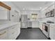 Modern kitchen with stainless steel appliances, white cabinets, and sleek black hexagon tile flooring at 2732 Lion Heart Rd, Winter Park, FL 32792