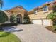 Stunning home with a three-car garage, tile roof and paver driveway with lush landscaping and mature palm trees at 2816 Northampton Ave, Orlando, FL 32828