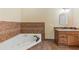 Bathroom featuring a corner tub with tile surround, a vanity with wood cabinets and granite countertops at 2839 Drifting Lilly Loop, Kissimmee, FL 34747