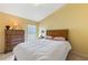 Bright bedroom with yellow walls, a wood-frame bed, and a dresser offers a warm and inviting space at 2839 Drifting Lilly Loop, Kissimmee, FL 34747