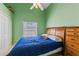 Green-walled bedroom features a ceiling fan, window with blinds, and wood furniture, creating a cozy atmosphere at 2839 Drifting Lilly Loop, Kissimmee, FL 34747