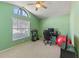 Bright green-walled bedroom with a computer desk, home office setup, and large window with natural light at 2839 Drifting Lilly Loop, Kissimmee, FL 34747