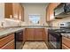 Functional kitchen with wood cabinets, black appliances, tile backsplash, and ample counter space at 2850 Retreat View Cir, Sanford, FL 32771