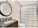Cozy bathroom featuring a granite vanity, round mirror, and a shower with a striped curtain at 2910 S Whisperbay Ct, Oviedo, FL 32765