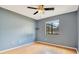 This bedroom features hardwood floors, a ceiling fan, and a large window with a view at 2910 S Whisperbay Ct, Oviedo, FL 32765