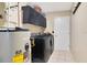 Practical laundry room with modern black washer, dryer and storage cabinets at 2910 S Whisperbay Ct, Oviedo, FL 32765