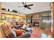 Inviting living room with brick fireplace, ceiling fan, leather furniture, and lots of natural light at 2910 S Whisperbay Ct, Oviedo, FL 32765