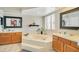 Bright primary bathroom featuring a soaking tub, dual vanities, and plenty of natural light at 2910 S Whisperbay Ct, Oviedo, FL 32765