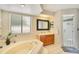 Bright main bathroom features soaking tub, a glass shower, and a large window at 2910 S Whisperbay Ct, Oviedo, FL 32765