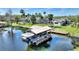 Aerial view of the house with a screen enclosed pool, a covered boat dock with a boat lift and canal at 29150 Beauclaire Dr, Tavares, FL 32778