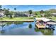 Aerial view features a boat dock, boat lift, lake, neighboring houses, and blue skies at 29150 Beauclaire Dr, Tavares, FL 32778