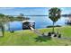 Aerial view of a boat dock, pontoon boat, and landscaped yard leading to a lake at 29150 Beauclaire Dr, Tavares, FL 32778