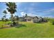 An attractive backyard featuring lush green grass, a screened-in patio, and elegant landscaping provides the ideal setting at 29150 Beauclaire Dr, Tavares, FL 32778