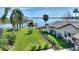 Spacious backyard with lush green lawn, mature palm trees, a fenced yard, and a private dock on a serene lake at 29150 Beauclaire Dr, Tavares, FL 32778