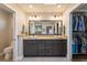 Well-lit bathroom features a double sink vanity with granite top and a walk-in closet at 29150 Beauclaire Dr, Tavares, FL 32778