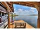 Pontoon boat on a covered lift, and a wooden bench on this dock for enjoying the lakeside views at 29150 Beauclaire Dr, Tavares, FL 32778